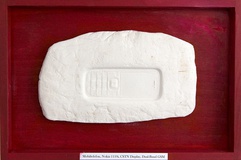 Thomas Kahl · Archäologische Funde IV (Mobiltelefon) · 2017 · Modelliermasse Tusche Holz · 20x30 cm